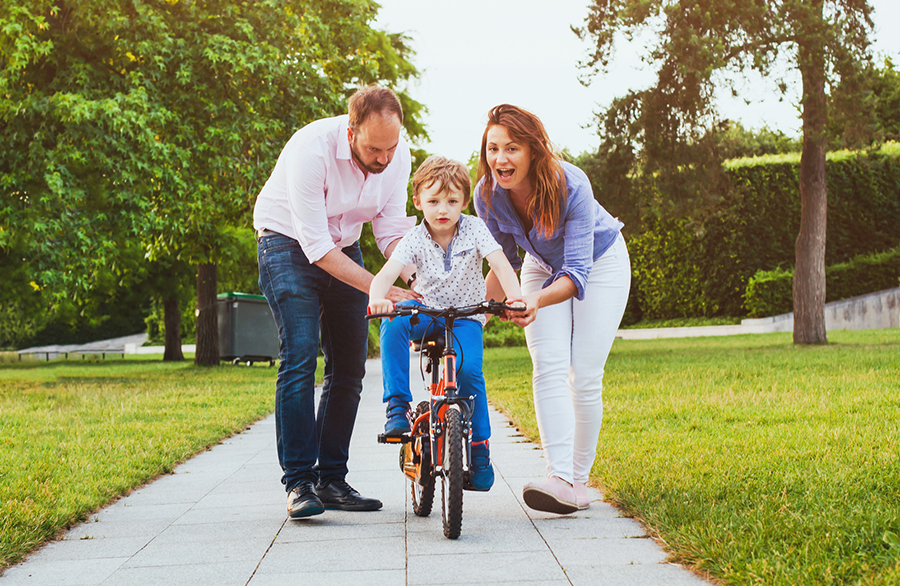 parents helping child to learn cycling Eye Associates of Boca Raton, P.A.